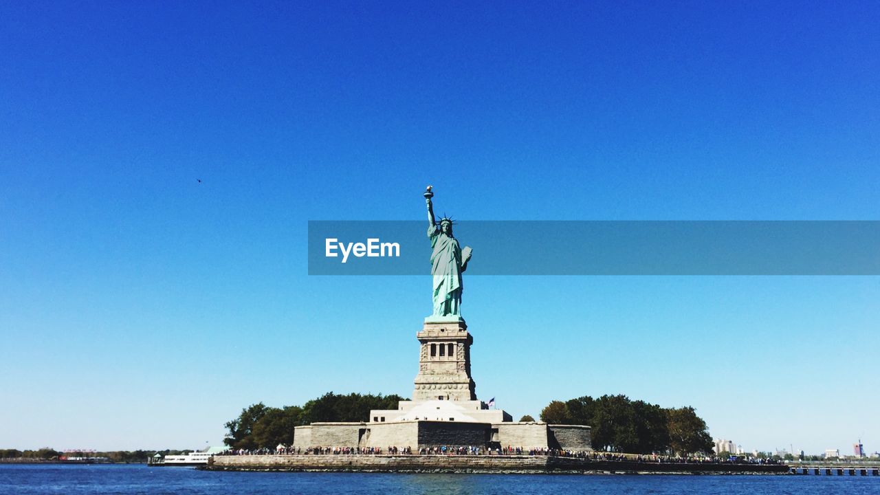 Low angle view of statue of liberty against blue sky