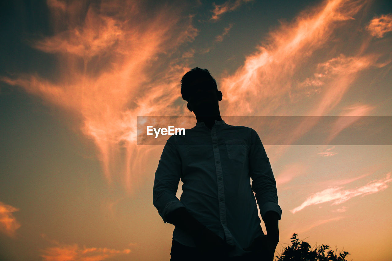 Silhouette man standing against sky during sunset