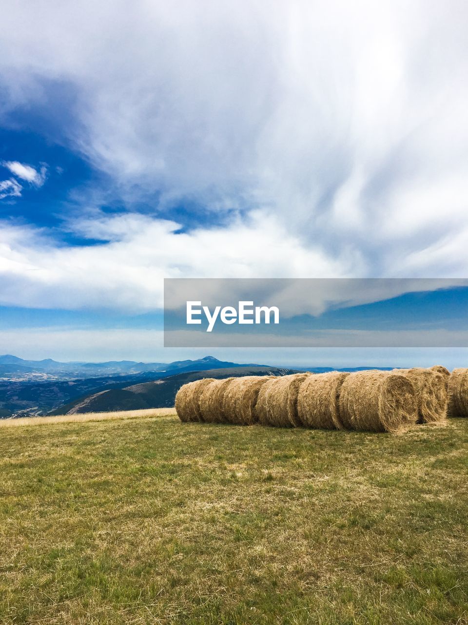 Hay bales on field against sky