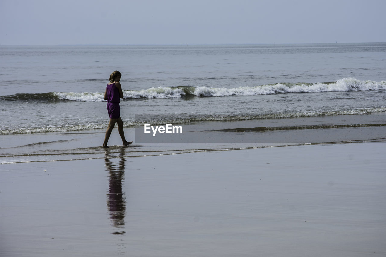 Full length of girl walking on shore at beach