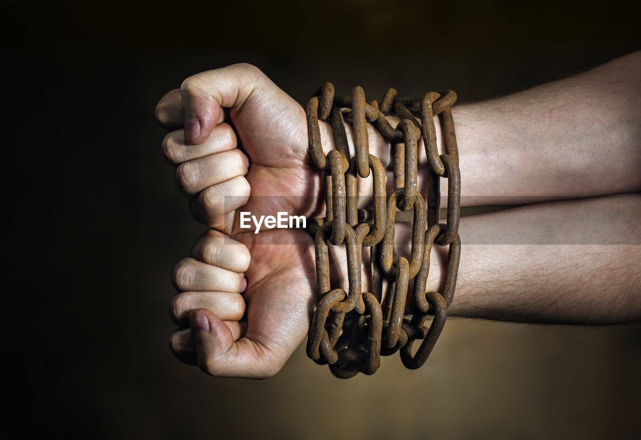 Close-up of hands trapped with chain