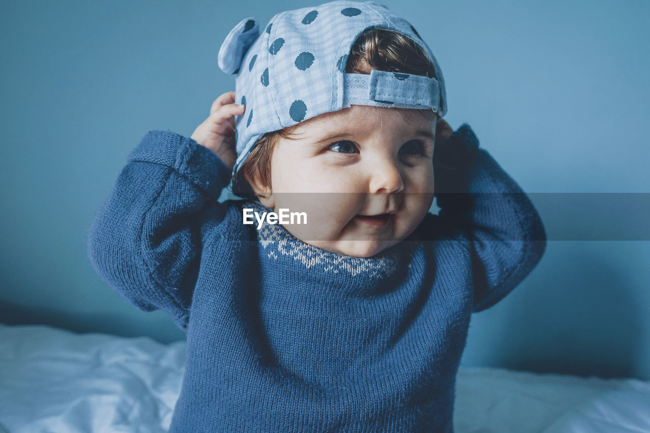 Cute girl looking away wearing cap at home