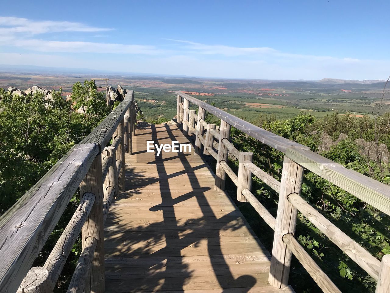 Footpath by railing against sky