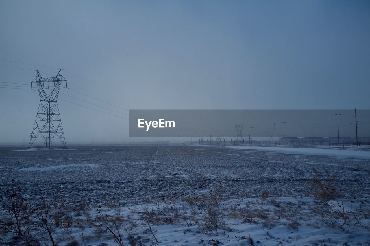 Electricity pylon on snowy field