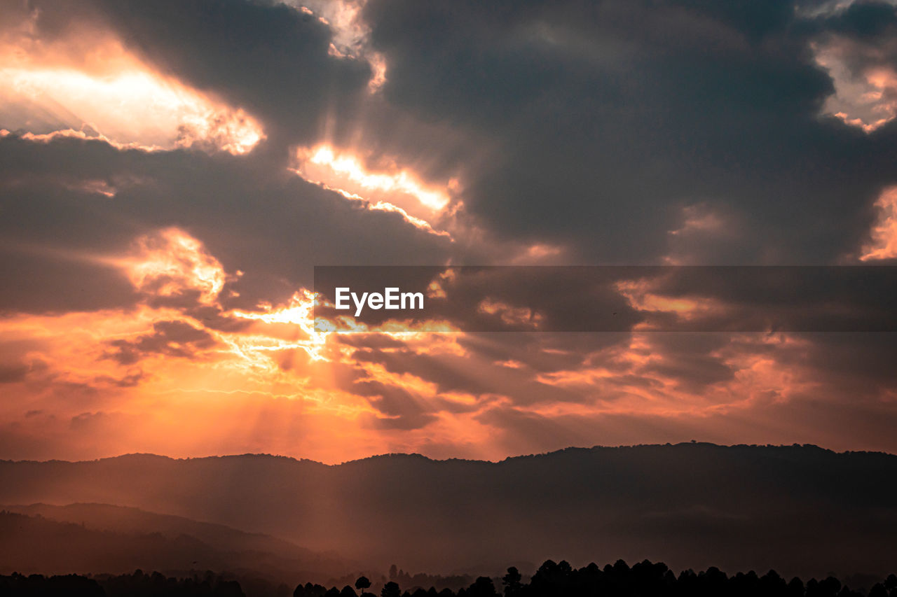 Dramatic orange sky with bleeding sun rays at dawn