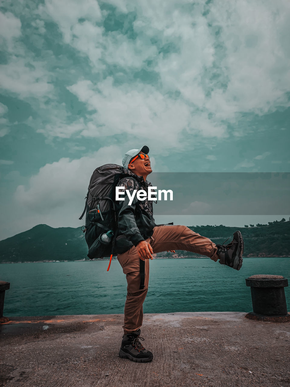 Side view of man standing on mountain against sky