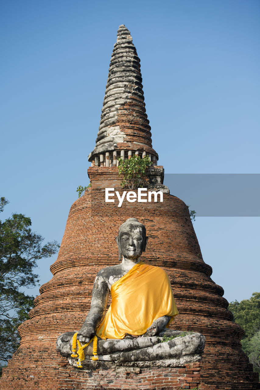 Low angle view of buddha statue at wat mahathat