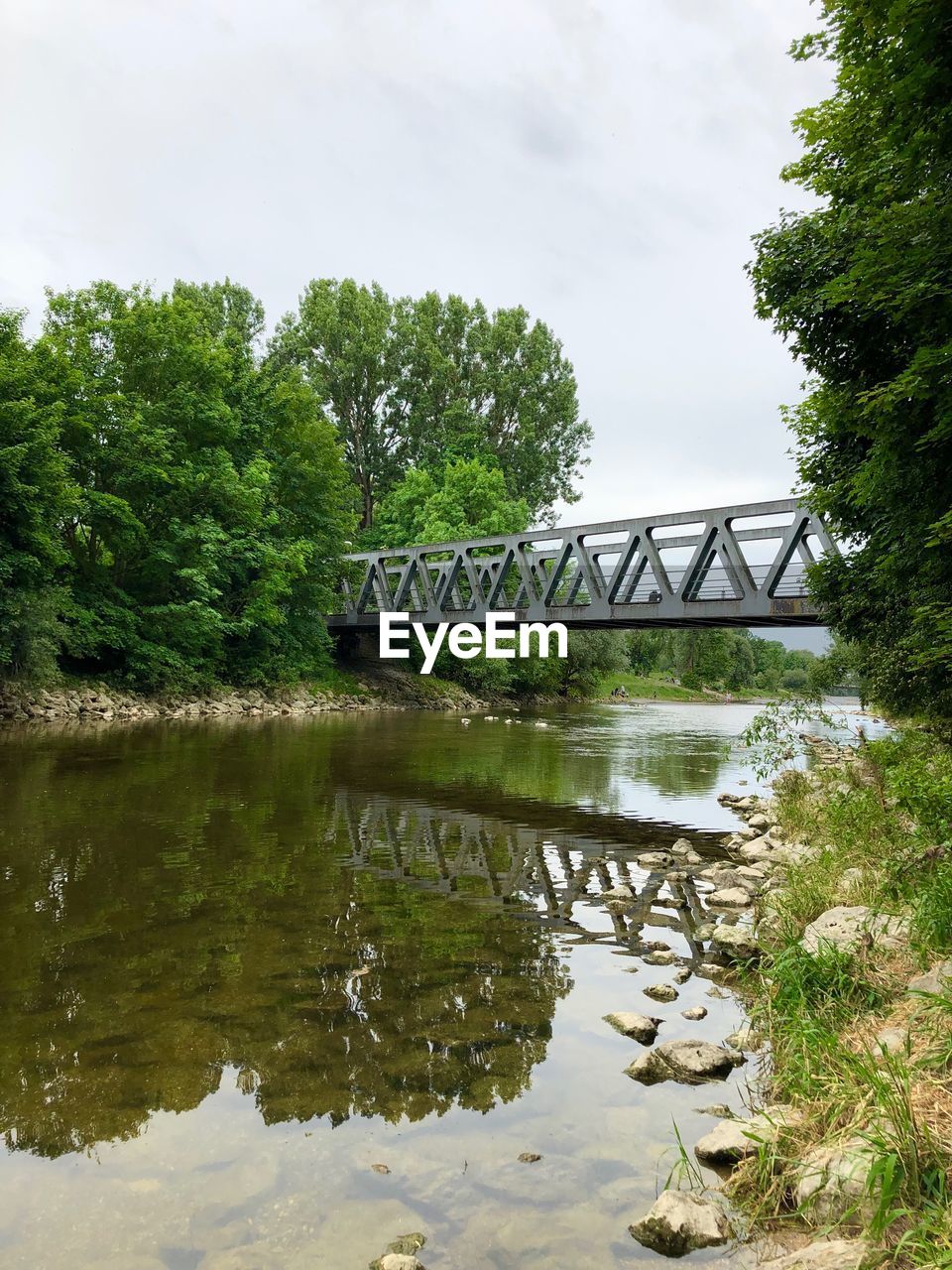 BRIDGE OVER LAKE AGAINST TREES