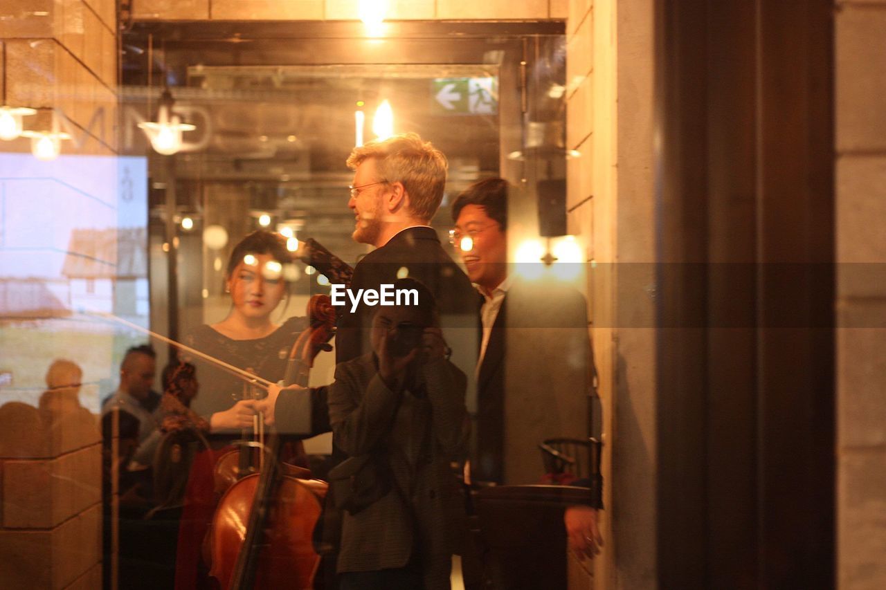 PEOPLE STANDING IN GLASS BUILDING