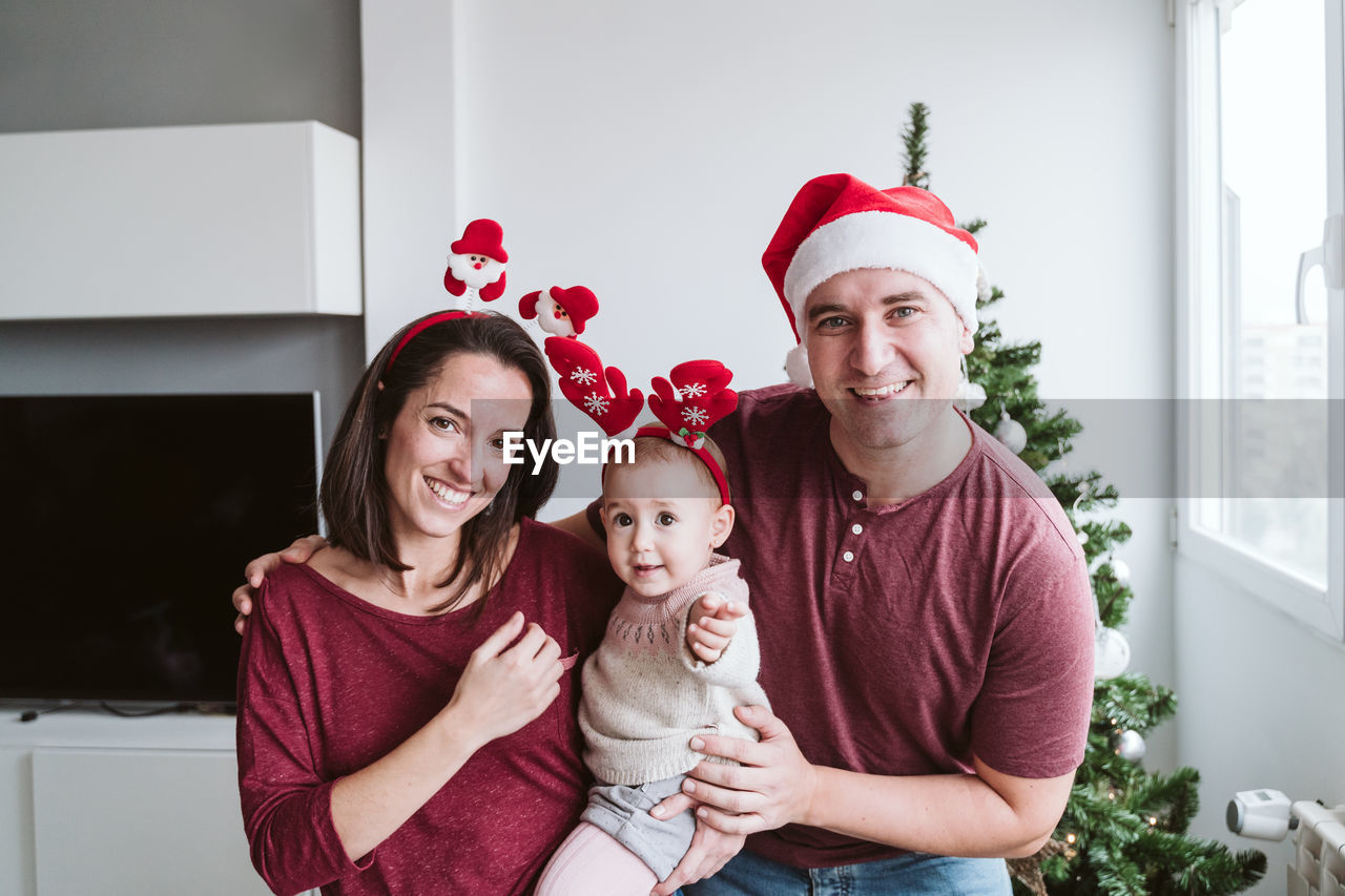 Baby girl with parents at home during christmas
