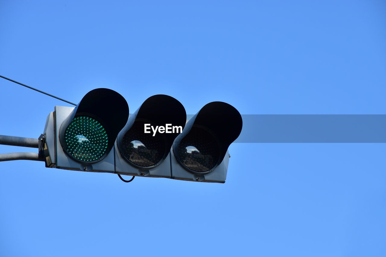 Low angle view of road signal against clear blue sky