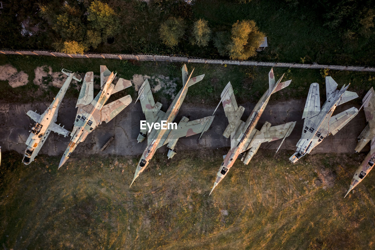 HIGH ANGLE VIEW OF DRY LEAVES HANGING ON METAL FENCE