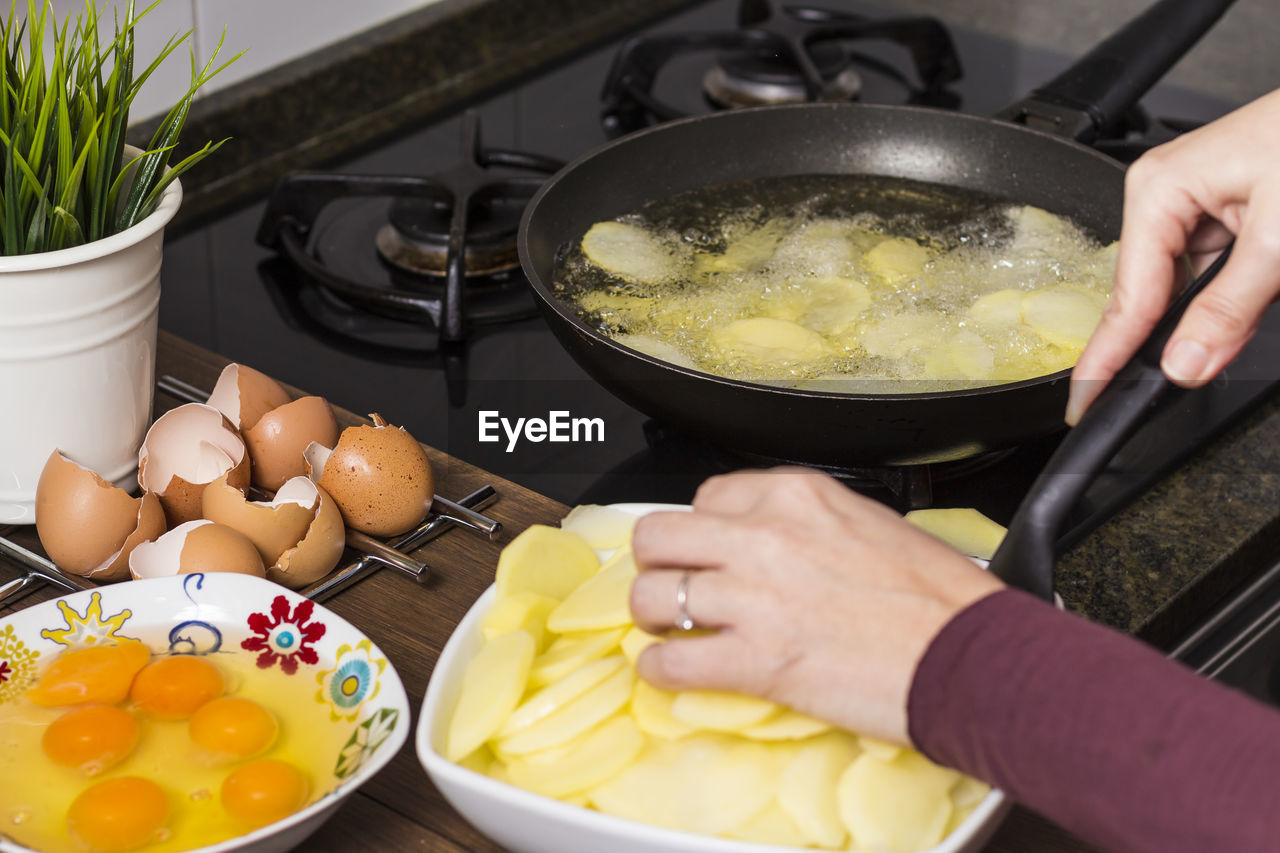 Cropped image of hands preparing food in kitchen at home