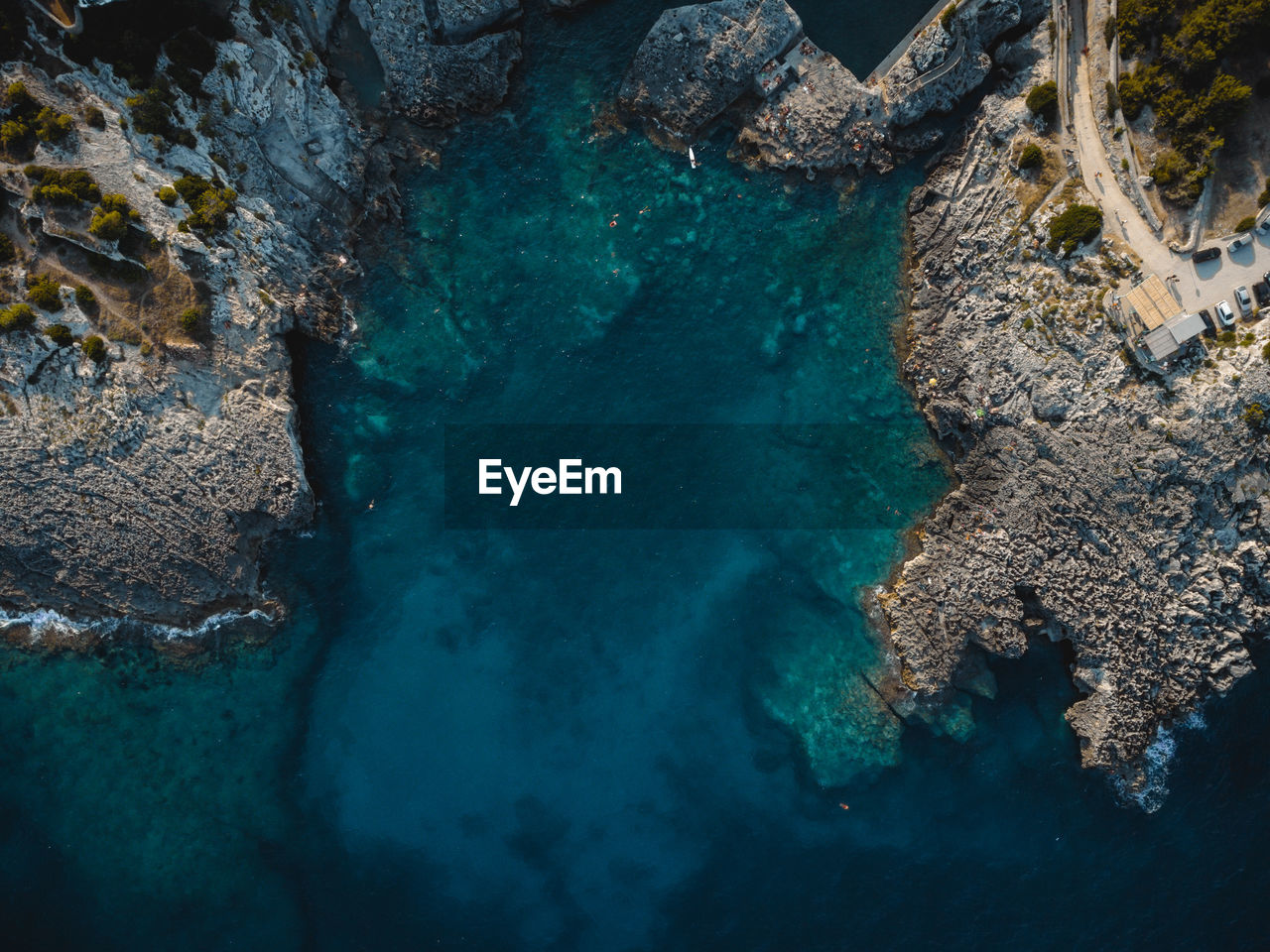 HIGH ANGLE VIEW OF ROCKS AND SEA