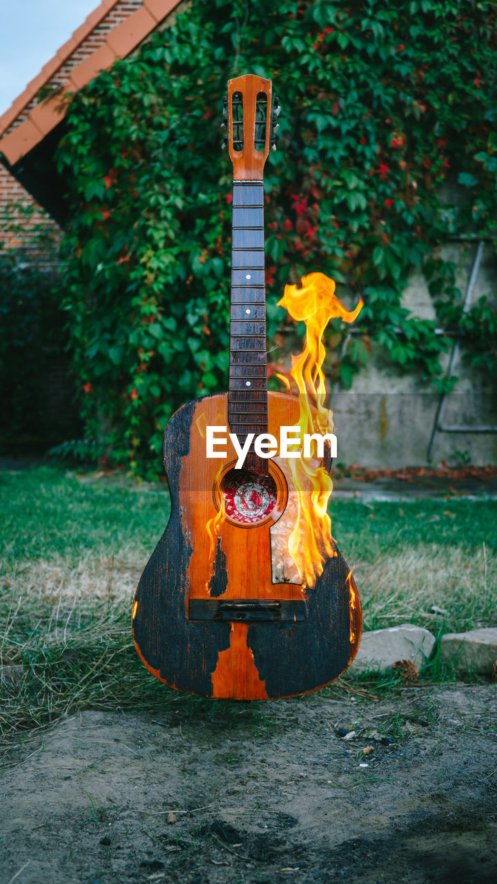 CLOSE-UP OF GUITAR ON FIELD BY CHAIN SWING