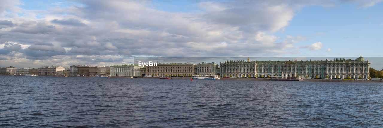 Buildings in city against cloudy sky