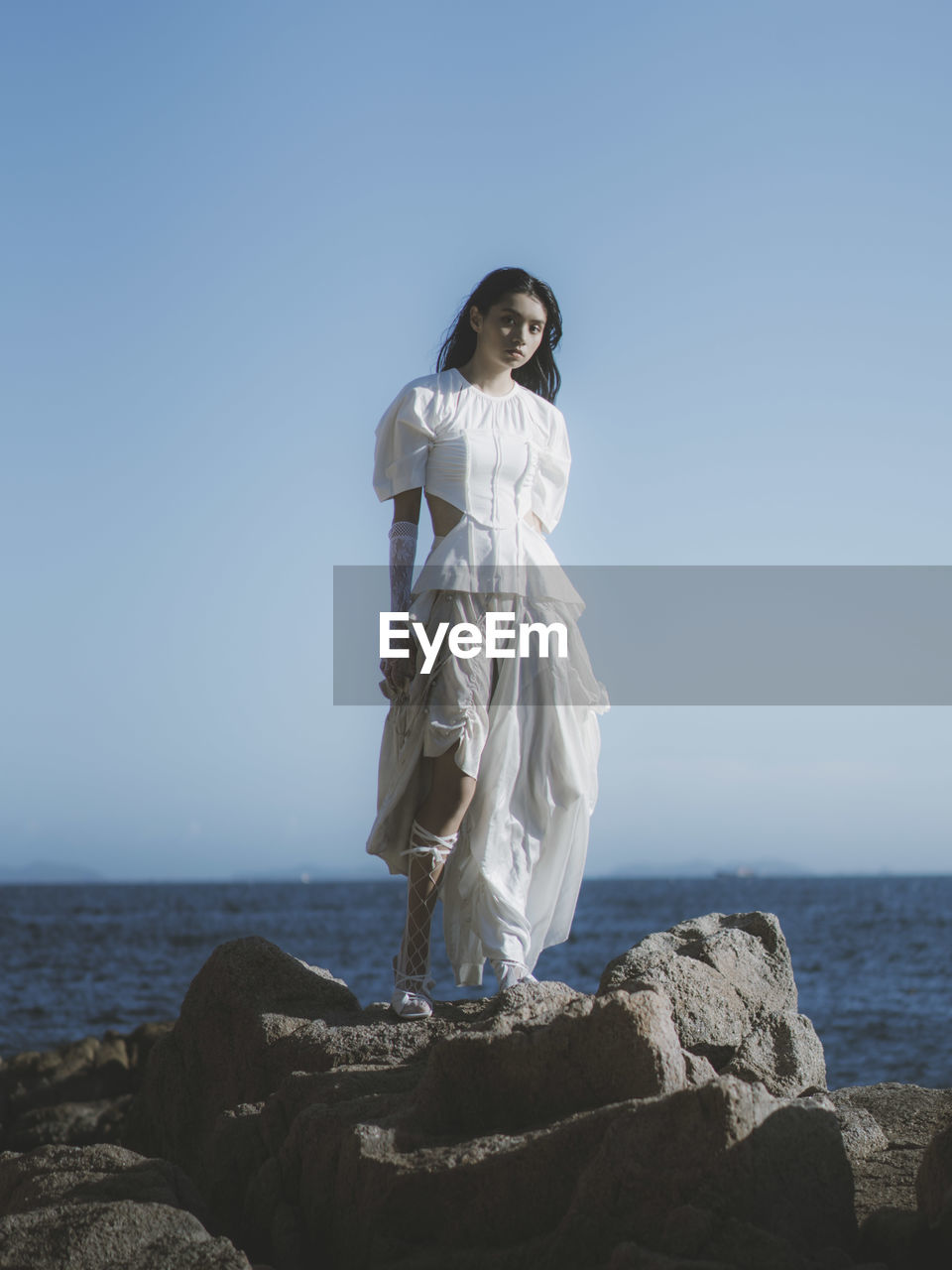 sea, sky, water, nature, monument, horizon over water, full length, statue, clear sky, beach, land, horizon, one person, rock, adult, sculpture, blue, ocean, women, standing, day, scenics - nature, beauty in nature, tranquility, outdoors, copy space, young adult, sunny, clothing, travel, travel destinations