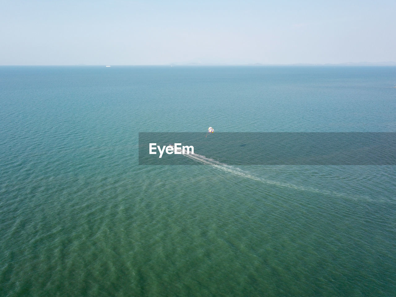 Aerial view parasailing activity at sea.