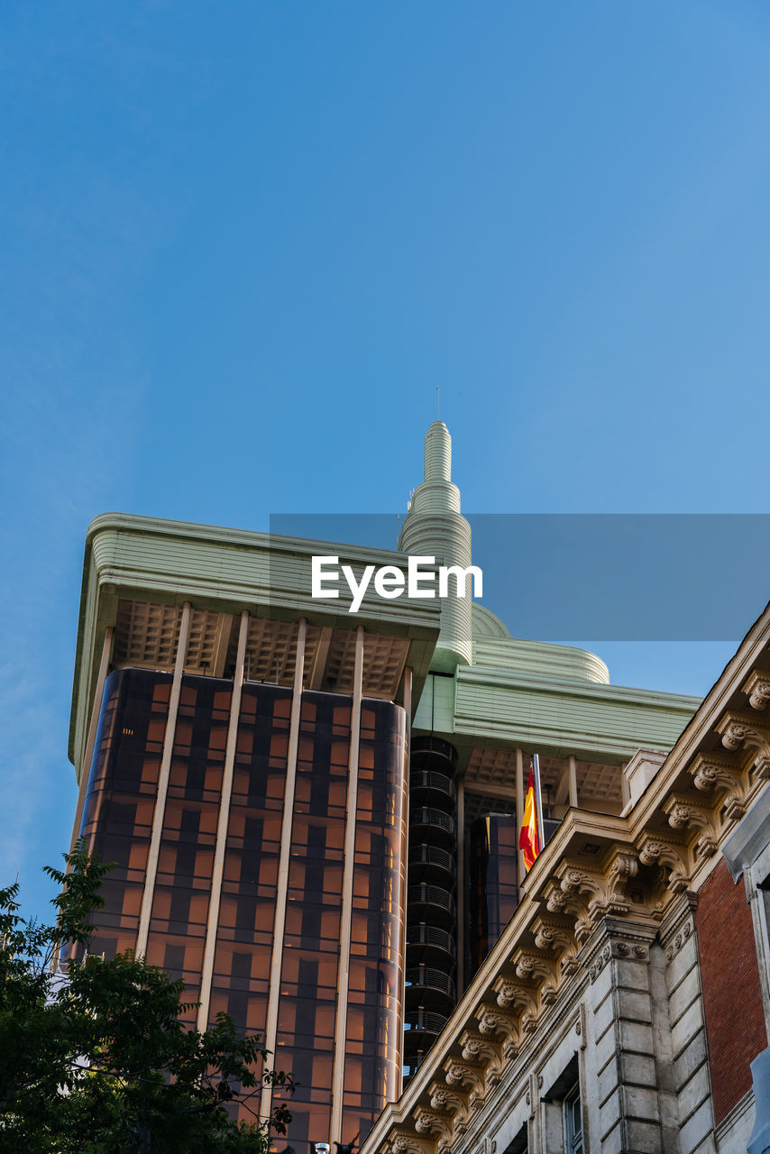 LOW ANGLE VIEW OF BUILDINGS AGAINST CLEAR BLUE SKY