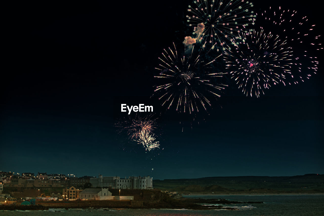 Low angle view of firework display against sky at night