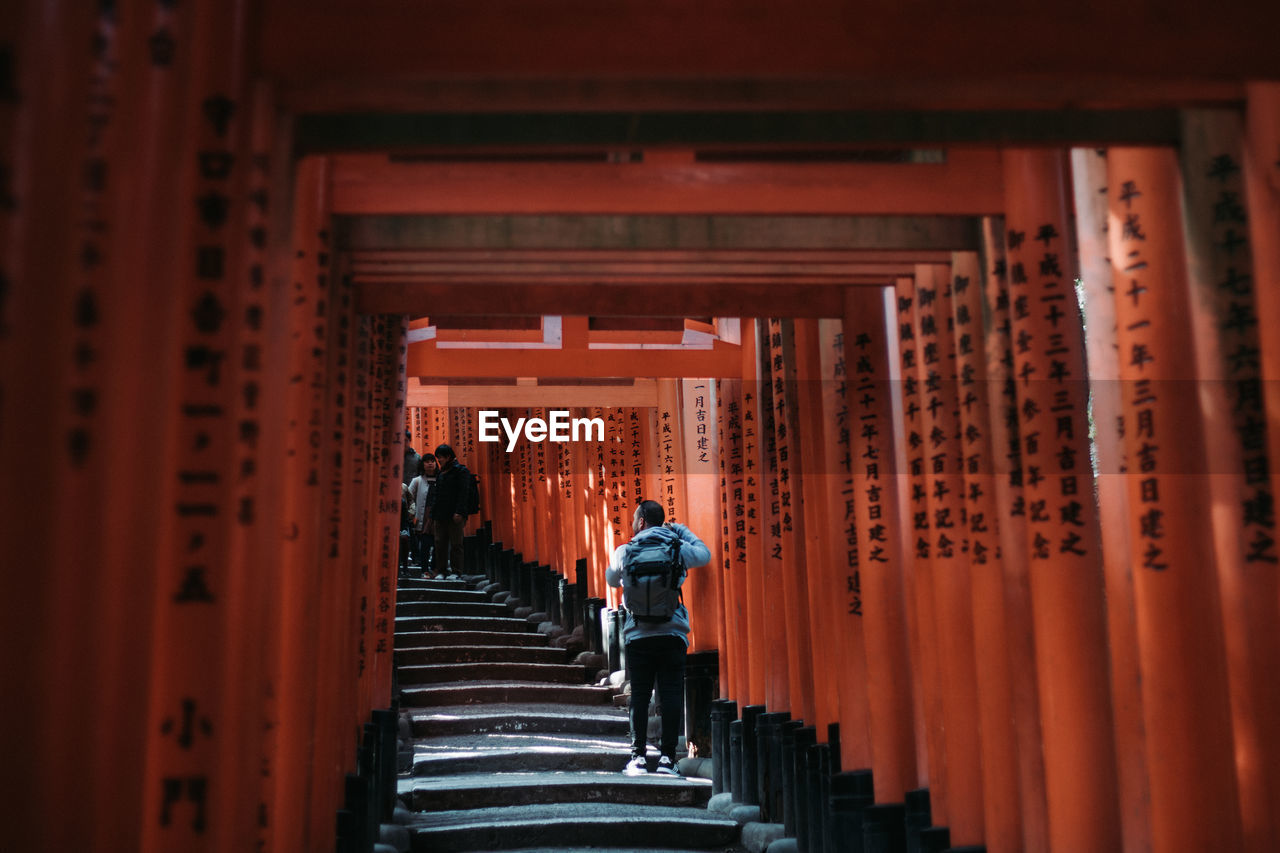 REAR VIEW OF TWO PEOPLE WALKING IN TEMPLE