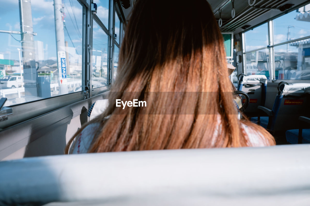 Rear view of woman sitting in bus