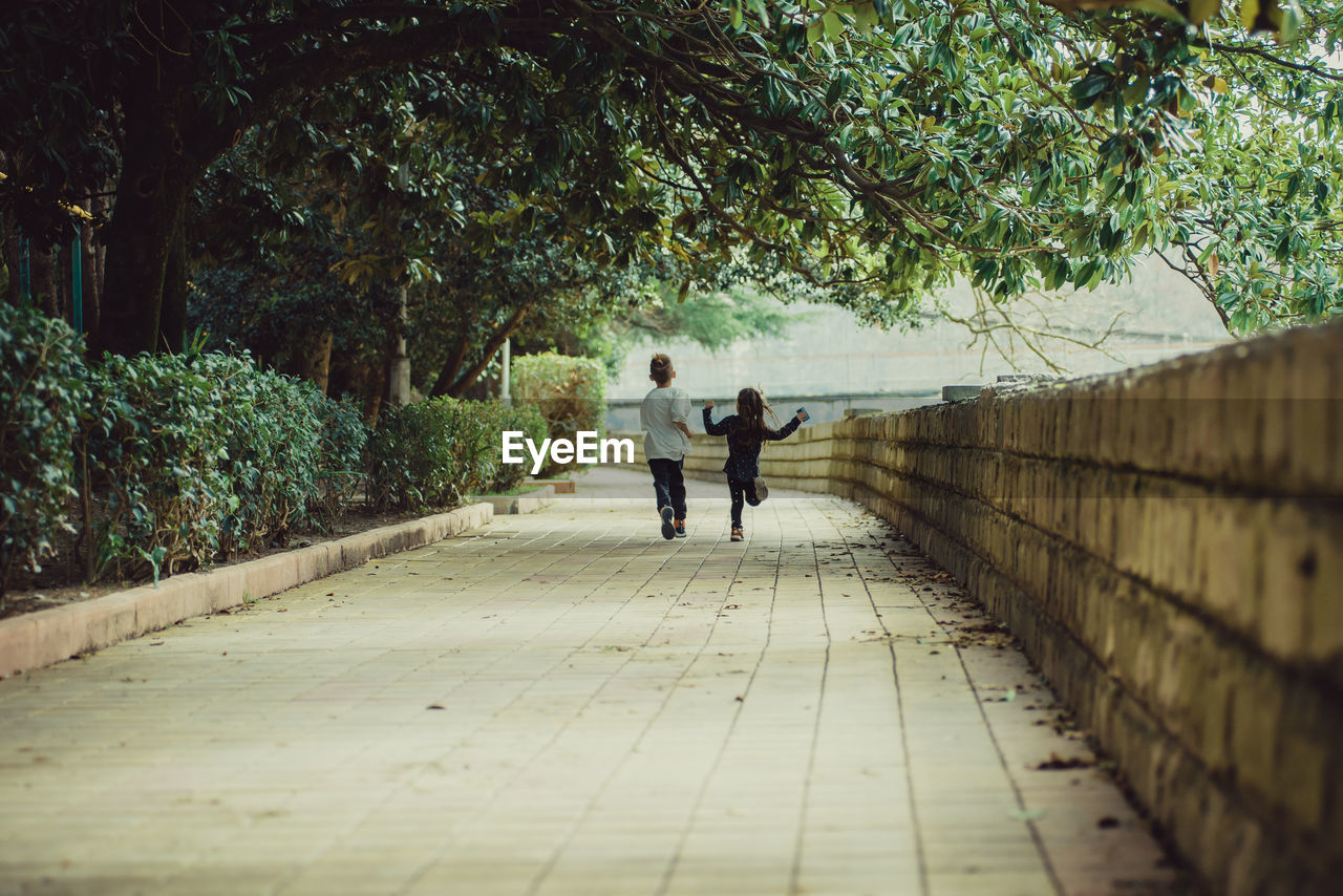 Two happy kids running away from the camera