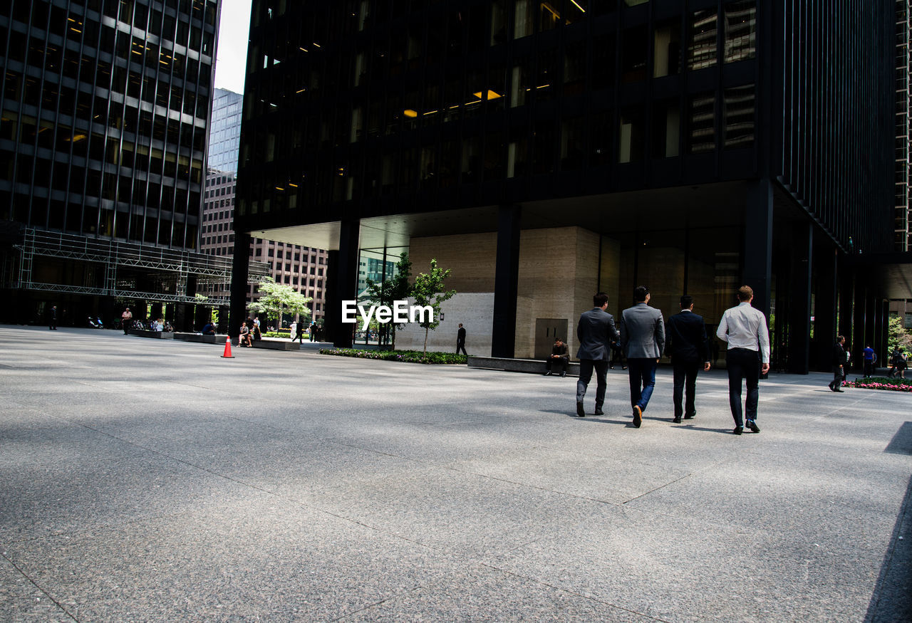 Businessmen walking on street in city