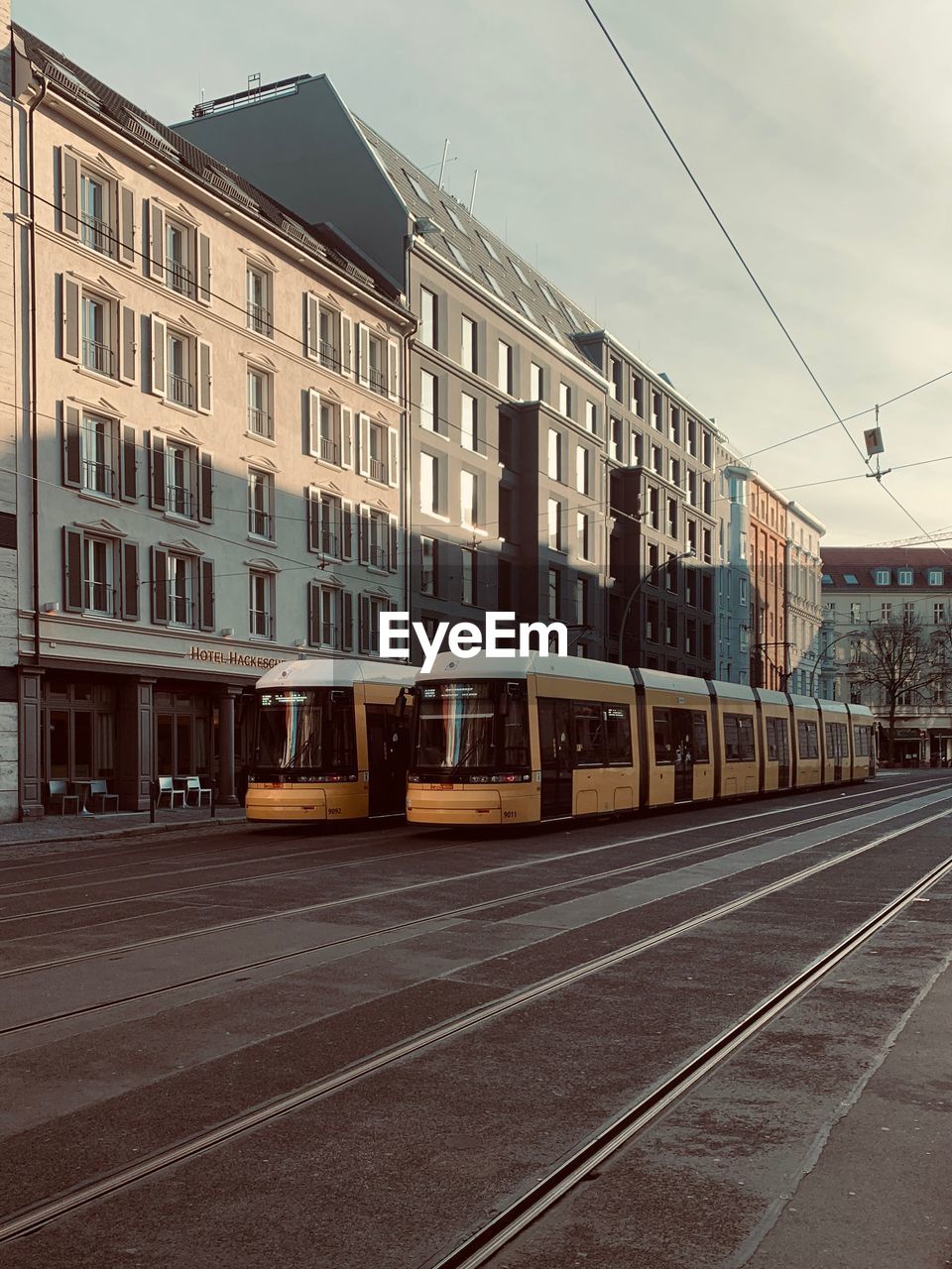 RAILROAD TRACK BY BUILDINGS IN CITY AGAINST SKY