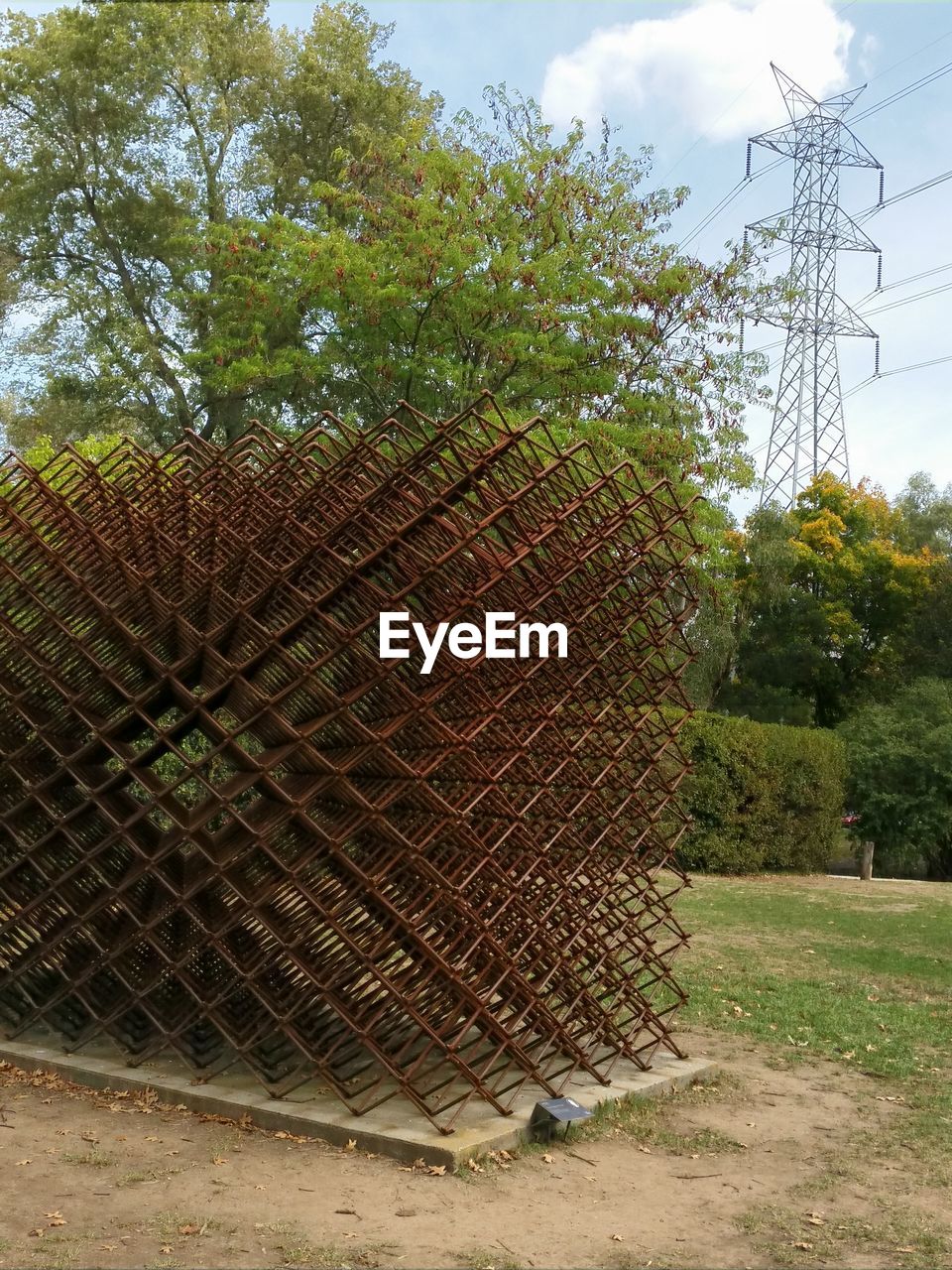 Metallic sculpture at park against sky