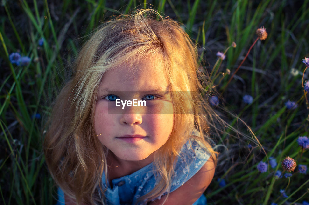 High angle portrait of girl sitting on field