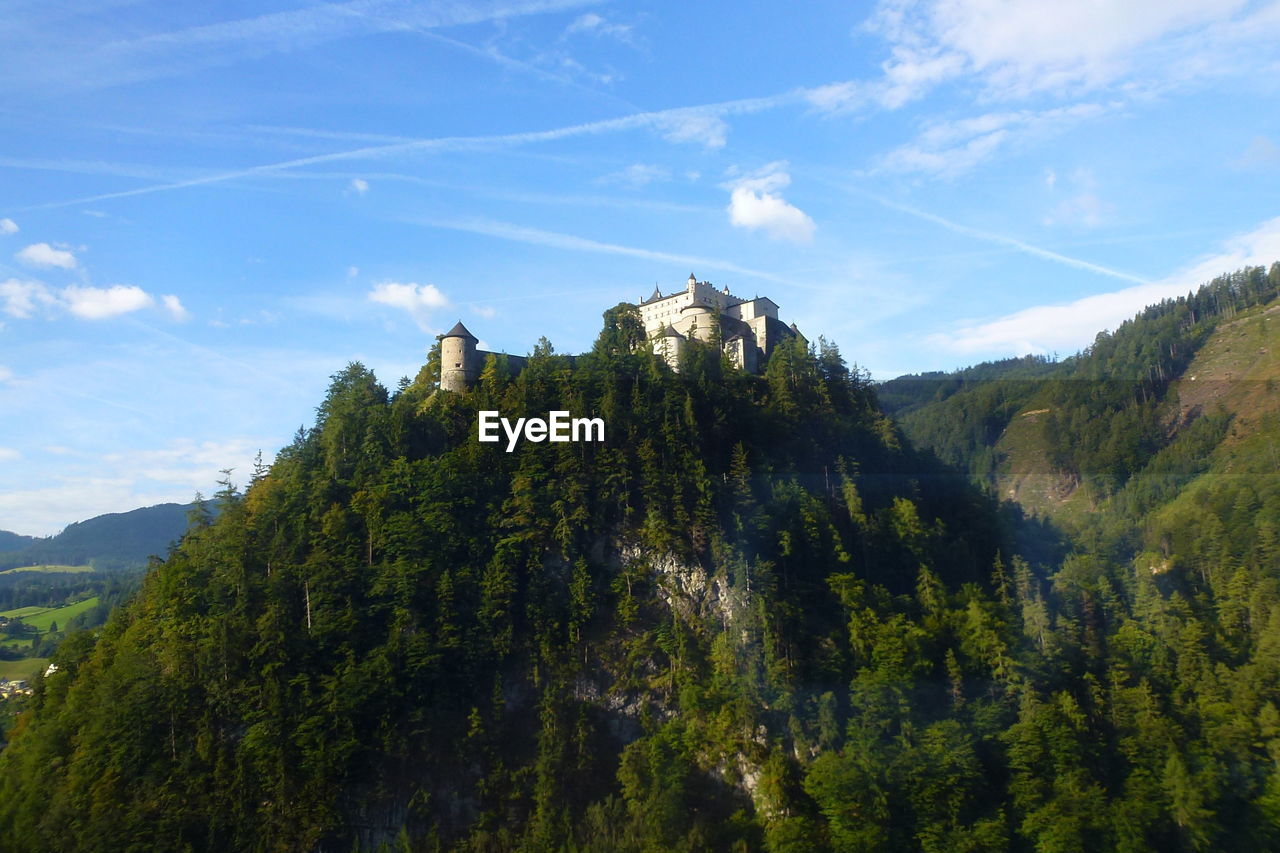 Castle on mountain against cloudy sky