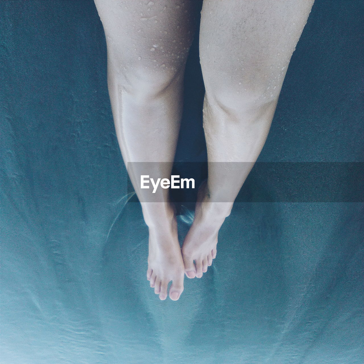 High angle view of woman legs on sea water