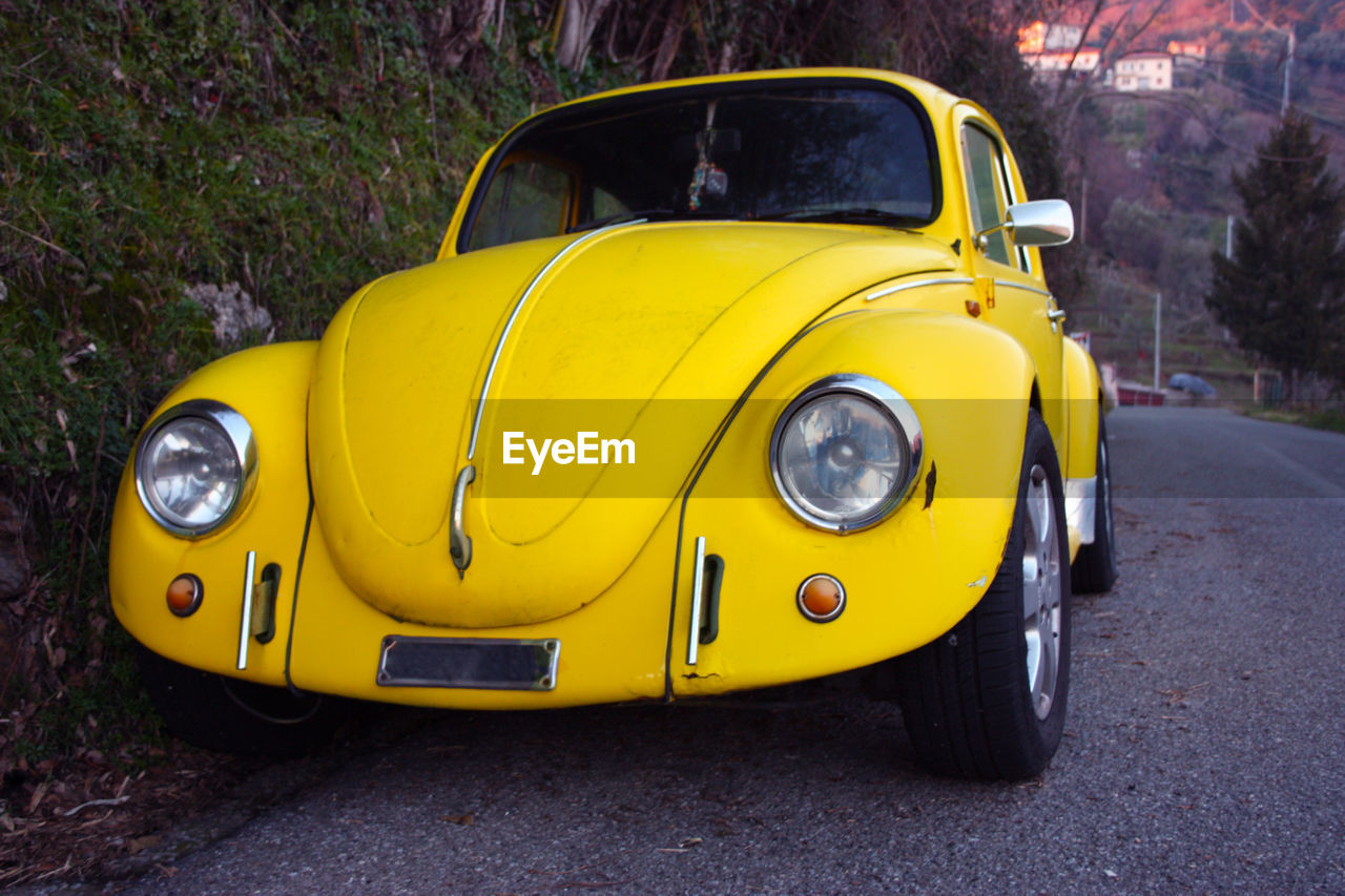 CLOSE-UP OF YELLOW CAR ON ROAD