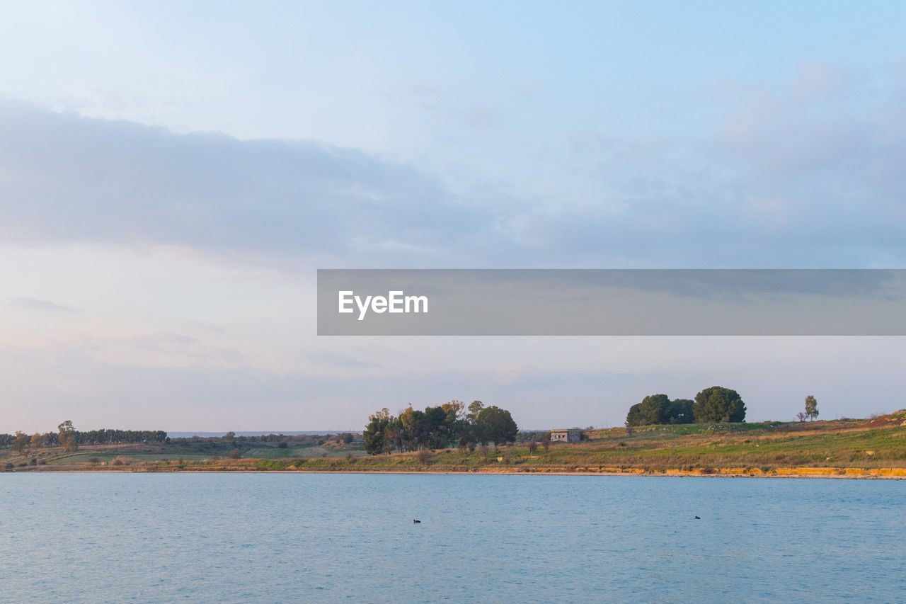 water, sky, shore, horizon, sea, cloud, nature, architecture, body of water, reflection, scenics - nature, built structure, no people, reservoir, environment, beauty in nature, tranquility, travel destinations, coast, tranquil scene, travel, bay, land, outdoors, landscape, day, morning, building exterior, tourism, building, waterfront, plant, tree, dusk, city