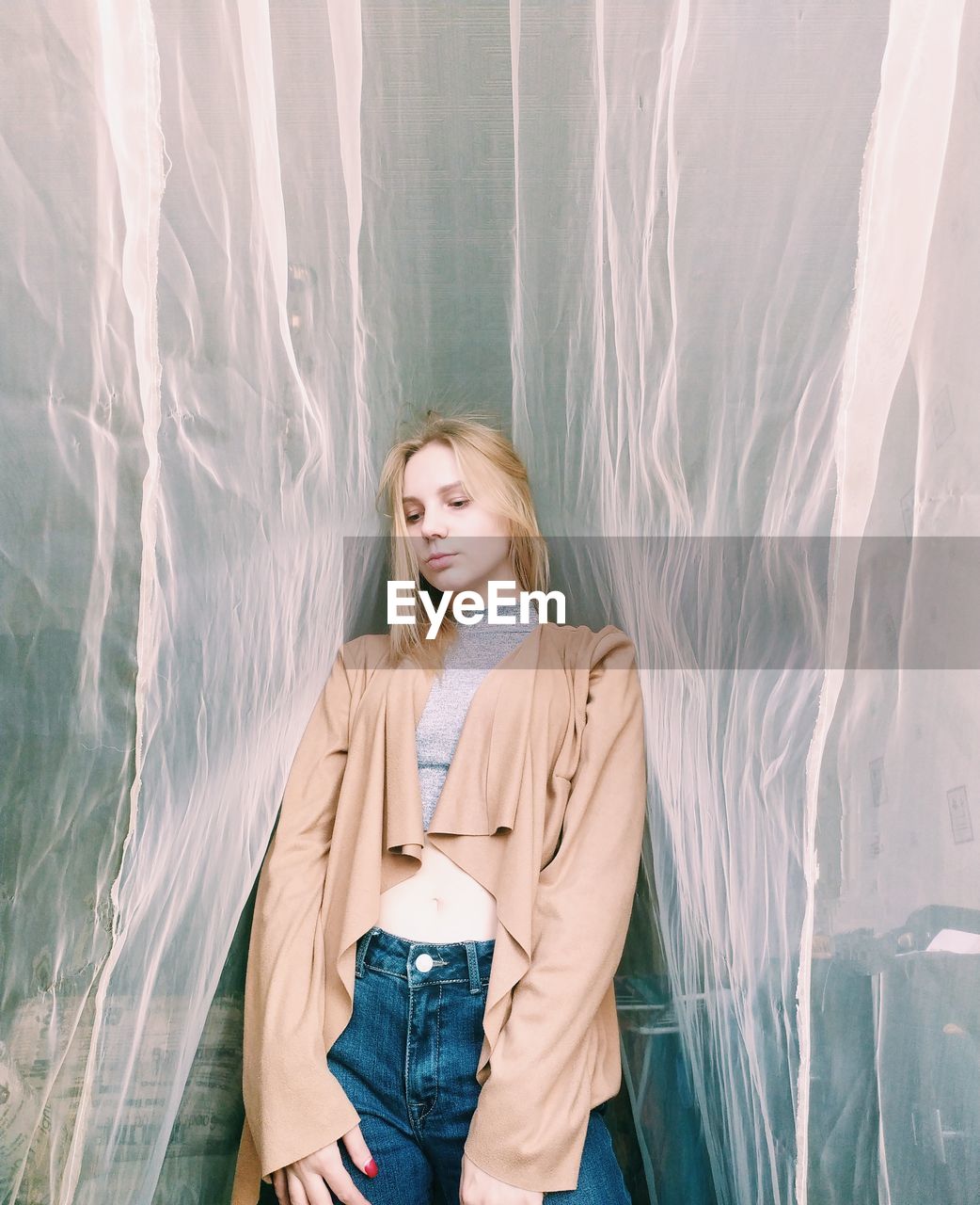 Beautiful young woman standing by plastic