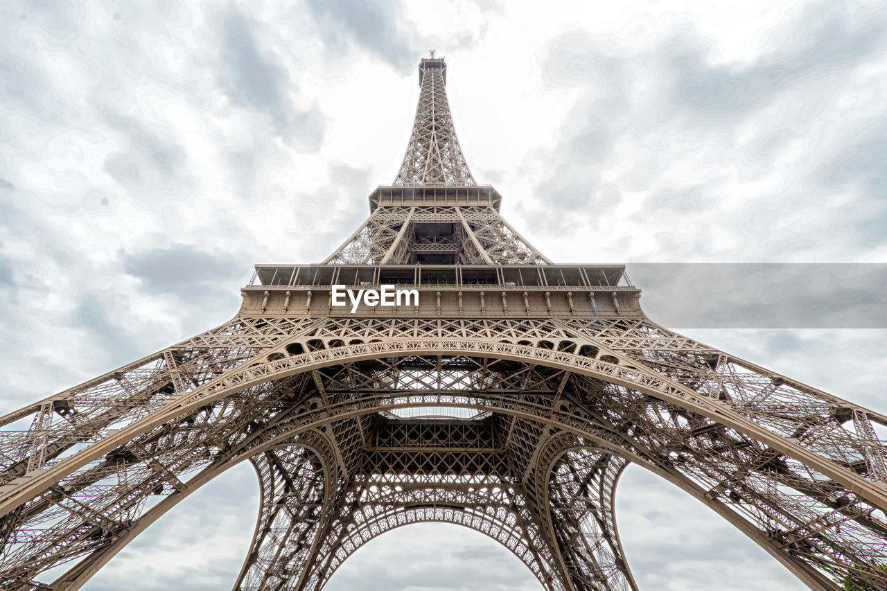 Low angle view of eiffel tower against cloudy sky