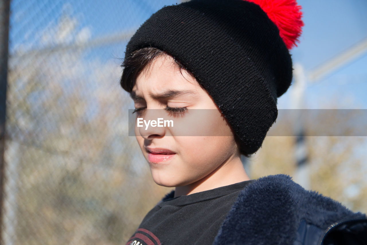 Outdoors portrait of boy with closed eyes