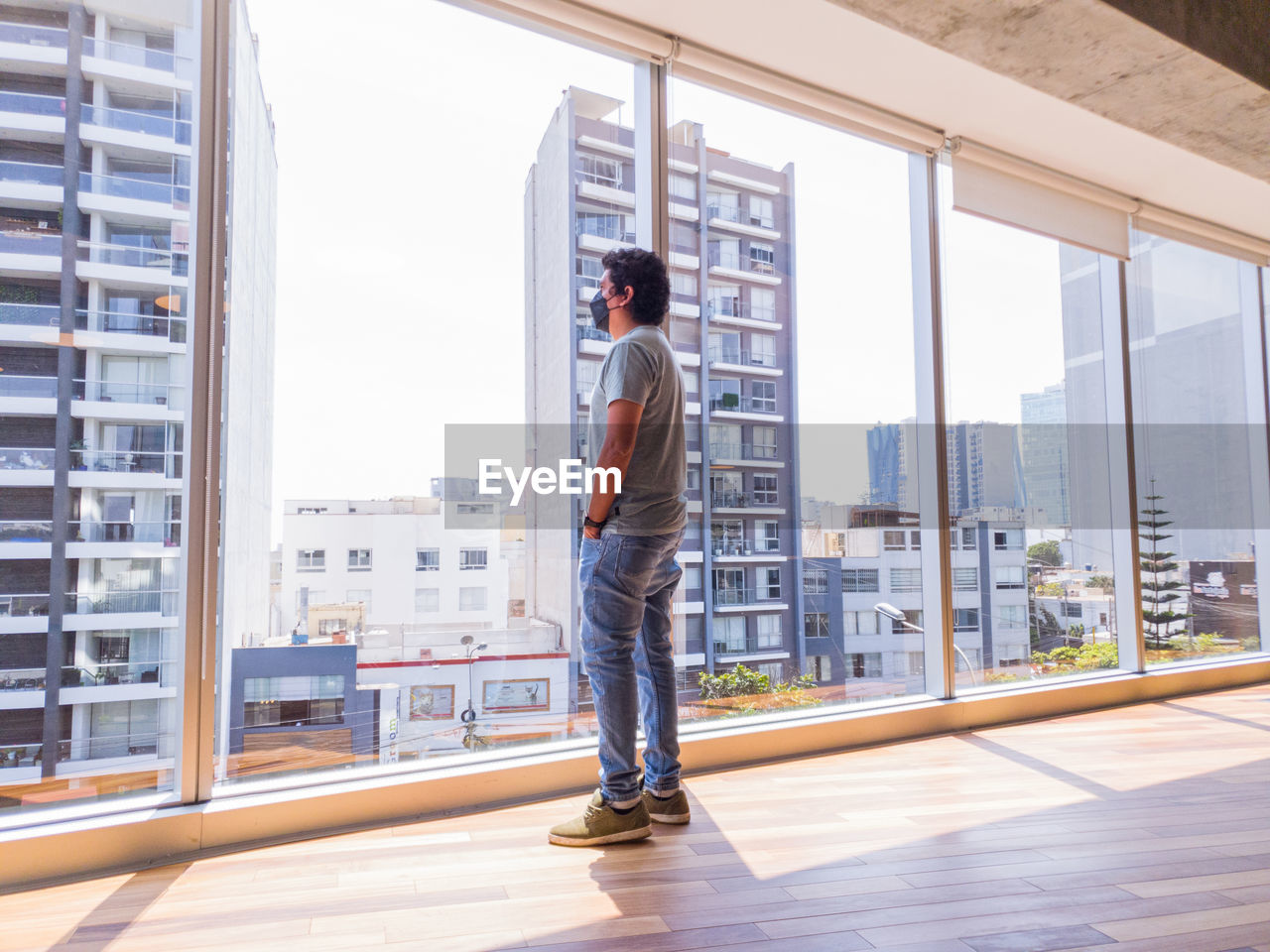 Young businessman looking through the windows in a big office