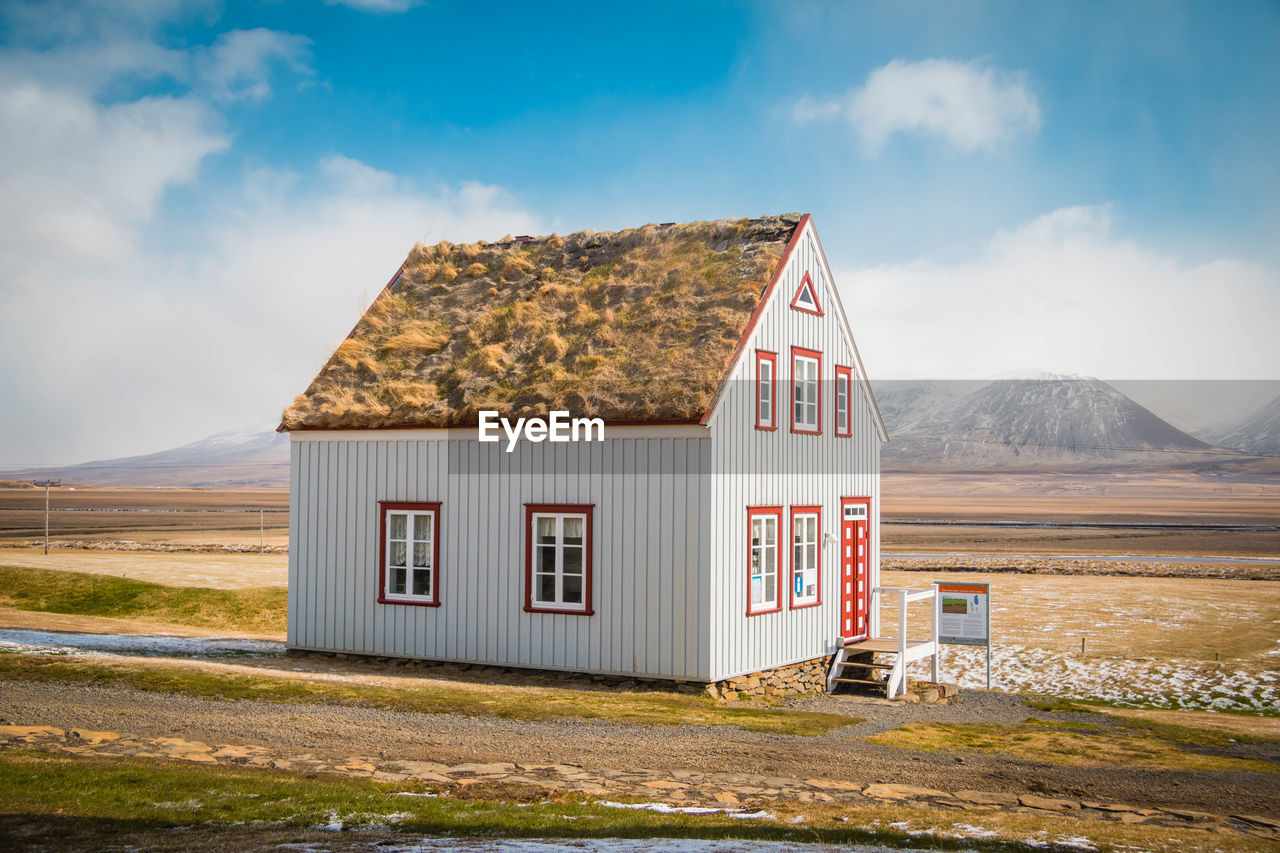 HOUSE AGAINST SKY AND MOUNTAIN