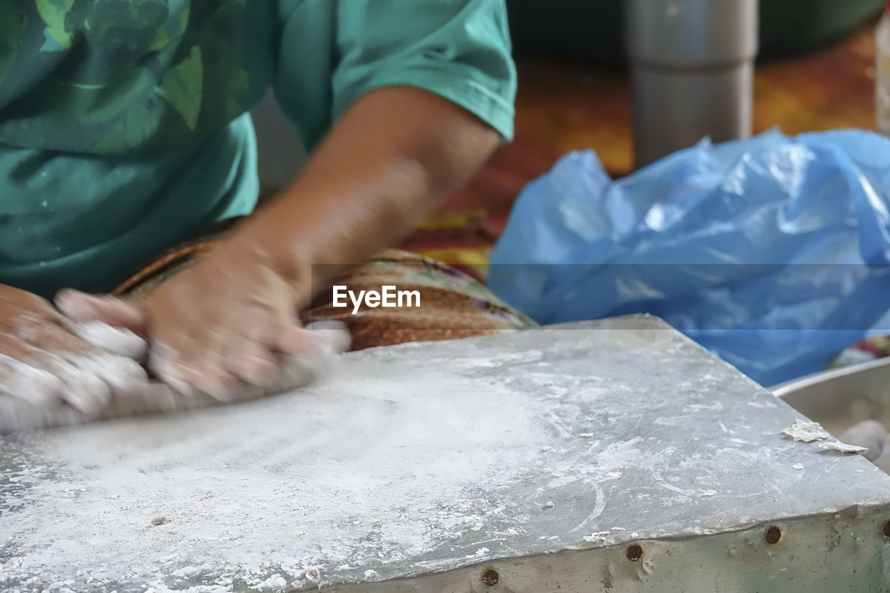 MIDSECTION OF PERSON WORKING ON TABLE