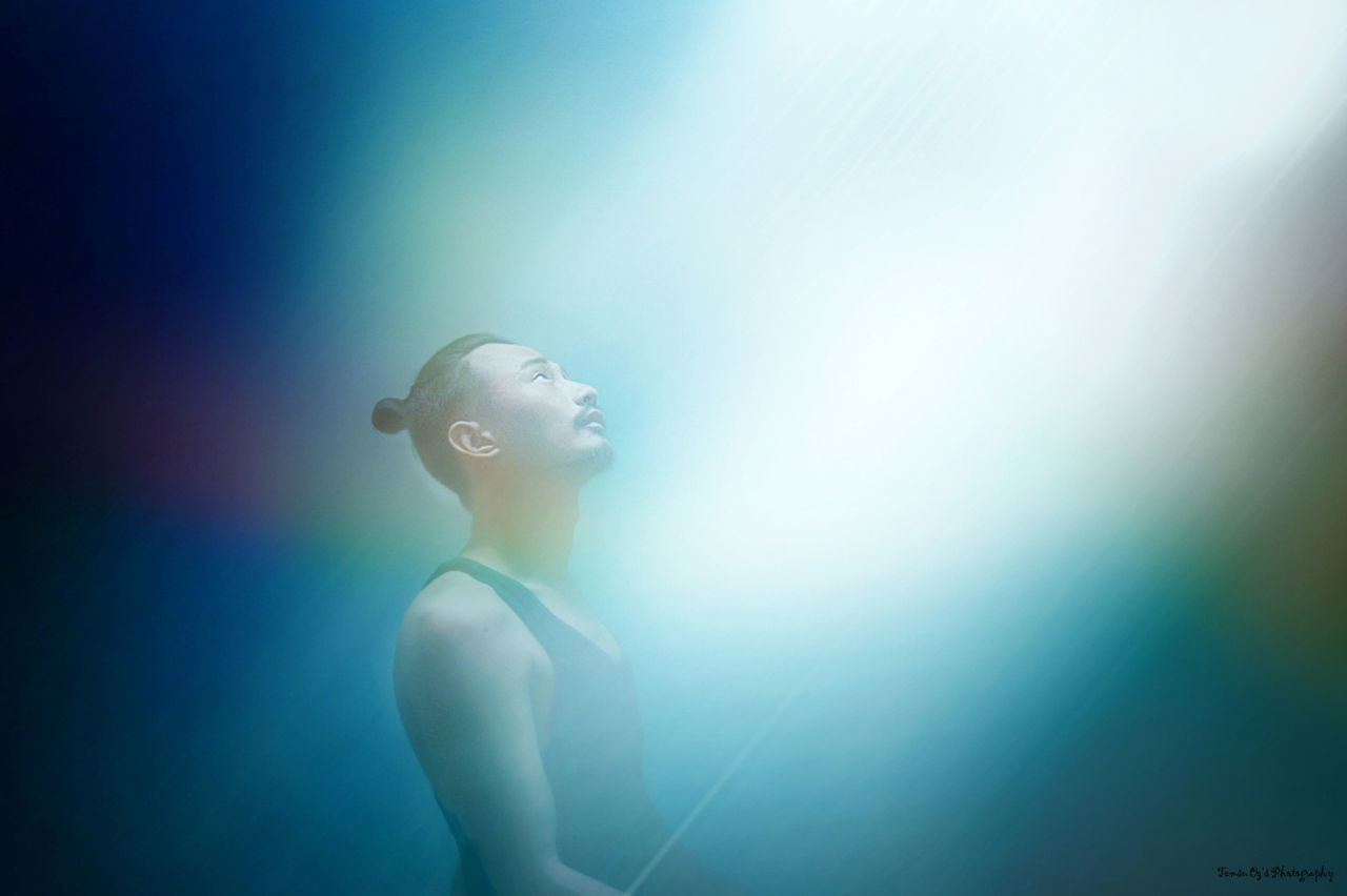 Man looking at light against blue background