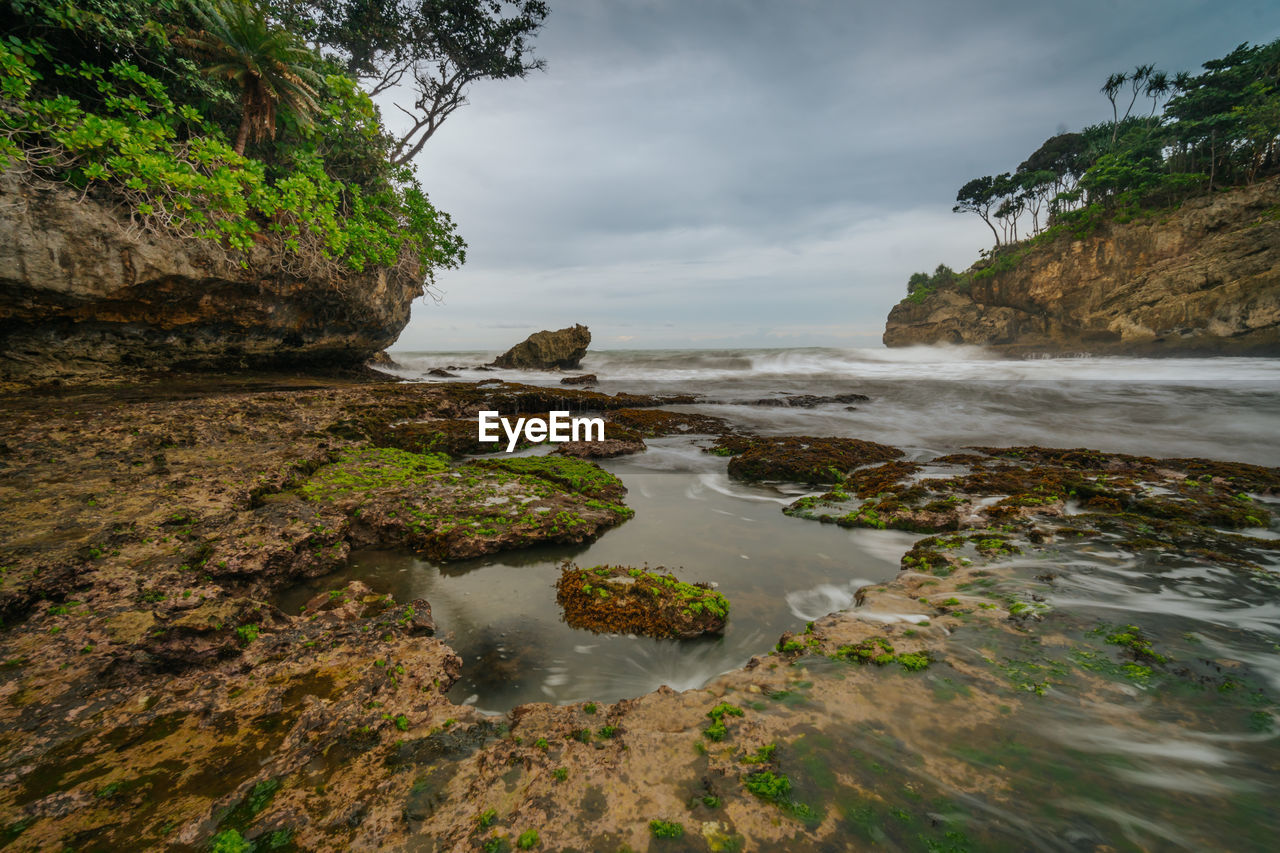 SCENIC VIEW OF ROCKS ON SEA AGAINST SKY