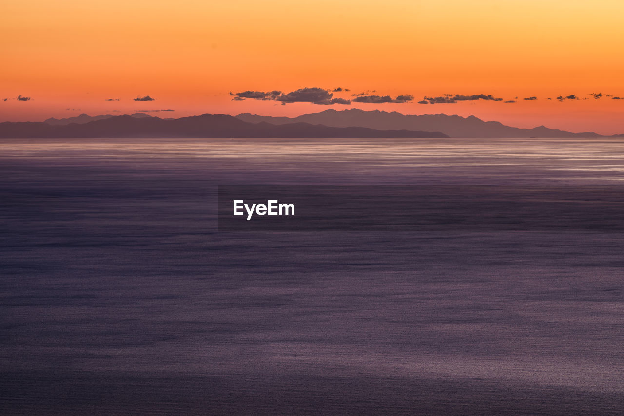 Scenic view of sea against orange sky