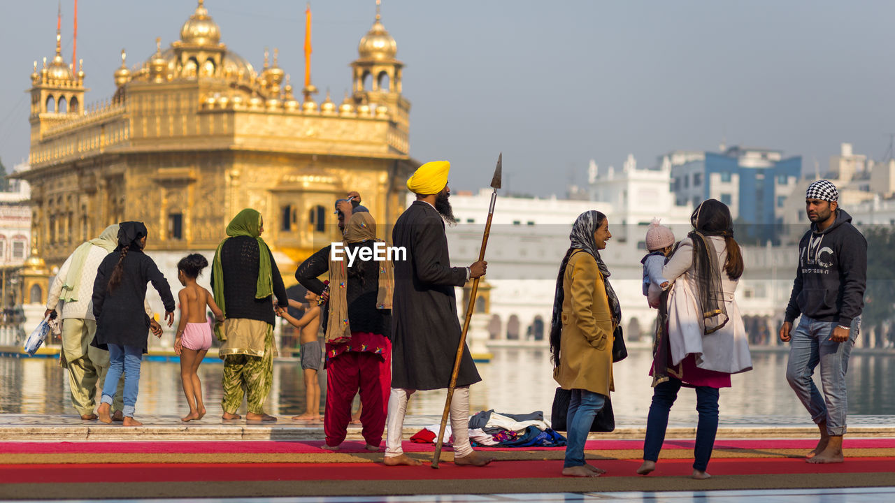 GROUP OF PEOPLE IN FRONT OF BUILDINGS