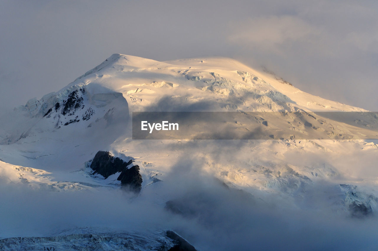 SNOW COVERED MOUNTAIN AGAINST SKY