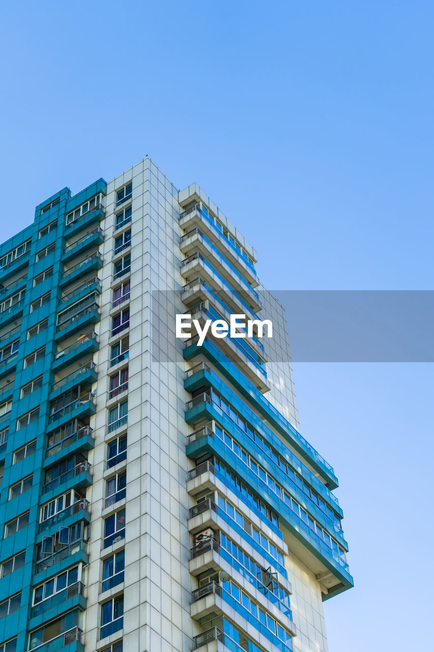 LOW ANGLE VIEW OF MODERN BUILDINGS AGAINST BLUE SKY