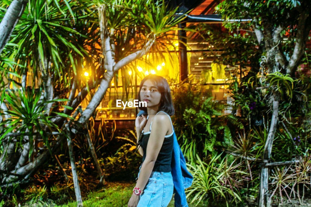 Portrait of girl standing by trees