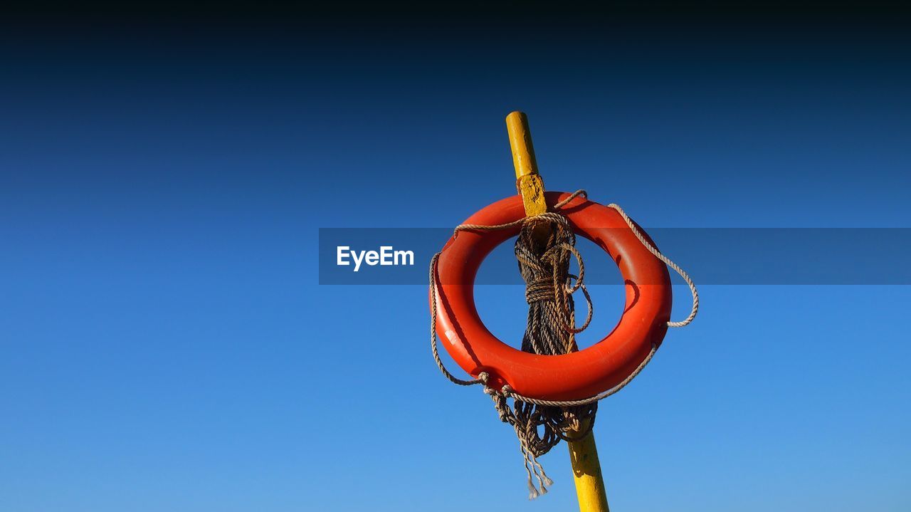 Low angle view of basketball hoop against clear blue sky