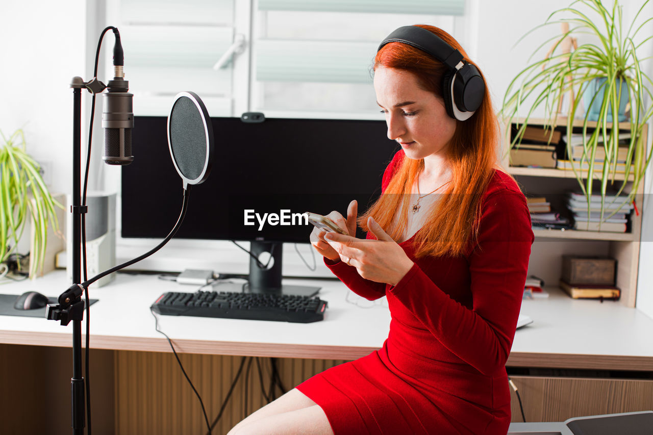 Side view of woman sitting in recording studio